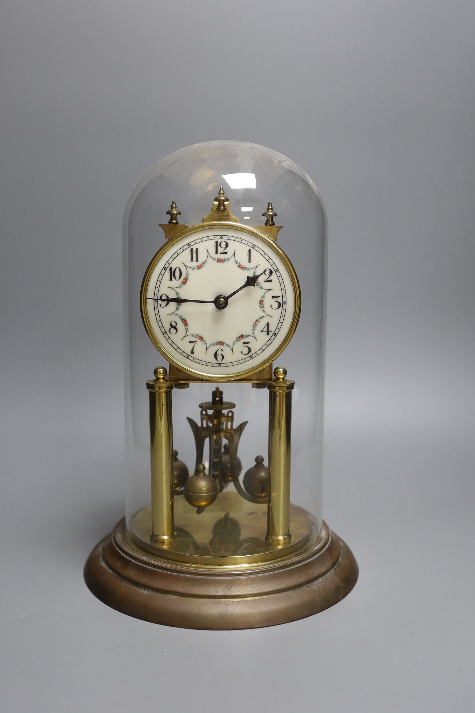 A German 400 day brass mantel timepiece, under a glass dome, 30cm total height